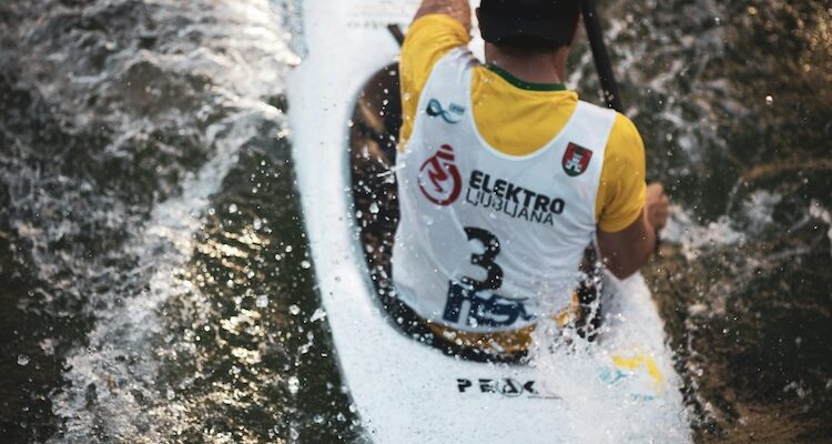 Canoe slalom racer navigating rapids in a flow state during a race in Ljubljana, Slovenia