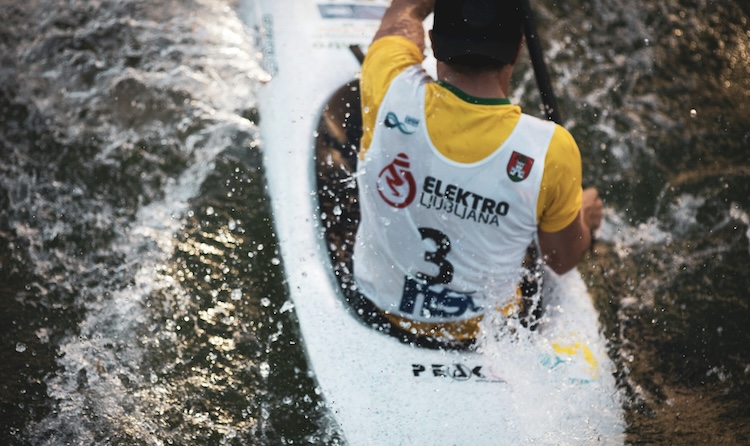 Canoe slalom racer navigating rapids in a flow state during a race in Ljubljana, Slovenia