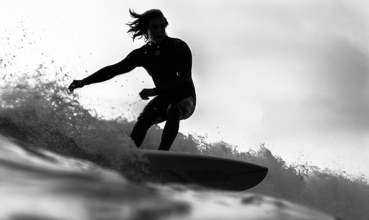 Black and white photo of a lone surfer riding a wave in a flow state off Morro Bay